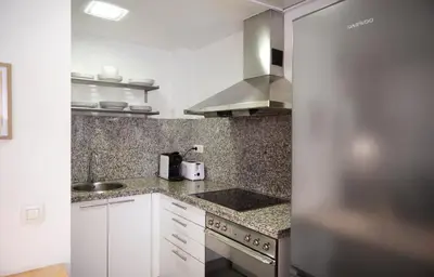 a kitchen with white cabinets and granite counter tops at SUN RAMBLA CATALUNYA GAUDI (Limpieza Desinfección) in Barcelona