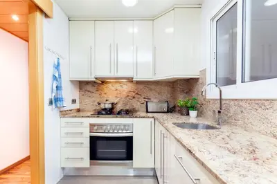 a kitchen with white cabinets and a sink at Click&Flat Fira Gran Via in Hospitalet de Llobregat