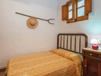 a bedroom with a bed and a hat on the wall at Cottage in Pacs near St Marti Sarroca Castle in Pacs del Penedes