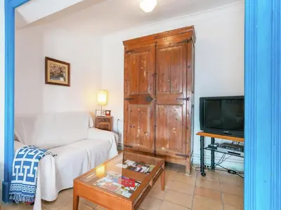 a living room with a white couch and a tv at Cottage in Pacs near St Marti Sarroca Castle in Pacs del Penedes
