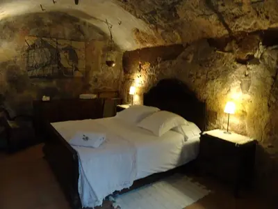 a bedroom with a bed in a stone room at Can Seuba in Rellinars