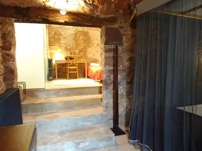 a room with a curtain in a stone wall at Can Seuba in Rellinars