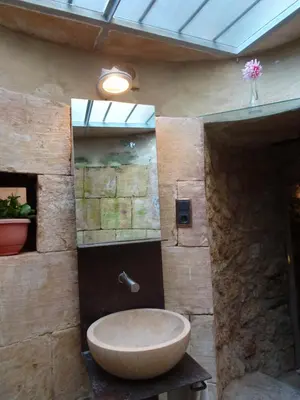 a bathroom with a large sink in a stone wall at Can Seuba in Rellinars
