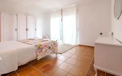 a bedroom with a bed and a tiled floor at Spacious House in Can Trabal in Can Trabal