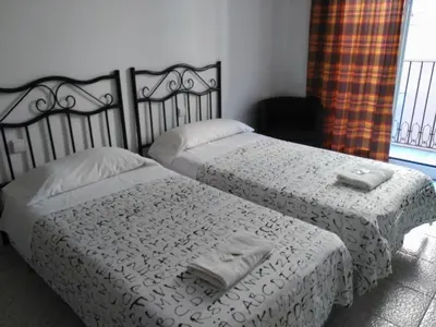 a bedroom with two beds with towels on them at Hostal River in Barcelona