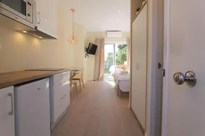 two wooden chairs and a table on a patio at Petit Bijou - Beach apartment III in Castelldefels