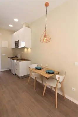a patio with a table and chairs on a lawn at Petit Bijou - Beach apartment III in Castelldefels