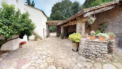 a stone walkway in front of a building with potted plants at Agroturisme Can Burguès in Santa Eulalia de Ronsaná