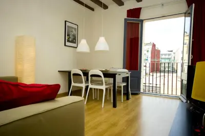 a living room with a table and chairs and a balcony at Sant Antoni Market in Barcelona