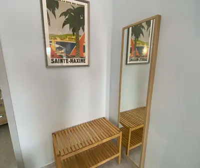 a mirror on a wall with a bench and a picture at Hotel Alexandra Sitges in Sitges