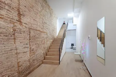 a brick wall in a hallway with a staircase at CAMP NOU & FiRA BUSINESS LOFTS in Barcelona