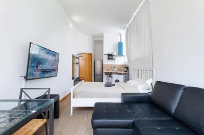 a living room with a couch and a bed at CAMP NOU & FiRA BUSINESS LOFTS in Barcelona
