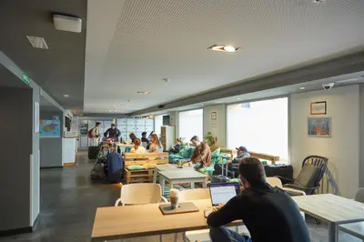a group of people sitting in a room with their laptops at St Christopher's Inn Barcelona in Barcelona