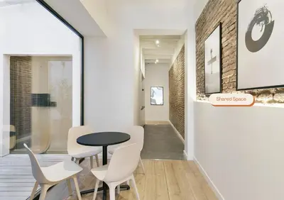 a dining room with a table and white chairs at Arte Suites by Olala! - Smart Stay in Hospitalet de Llobregat