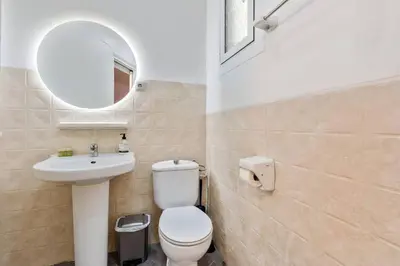 a bathroom with a toilet and a sink and a mirror at Quiet, Ultra-Central Stay KM0 for 3 in Barcelona