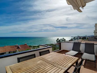 a balcony with a table and chairs and the ocean at Amazing Seaview Apartment by Hello Homes Sitges in Sitges