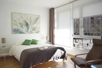 a bedroom with a bed and a chair and a window at CIUDADELA PARK 1 in Barcelona