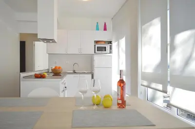 a white kitchen with two wine glasses on a table at CIUDADELA PARK 1 in Barcelona