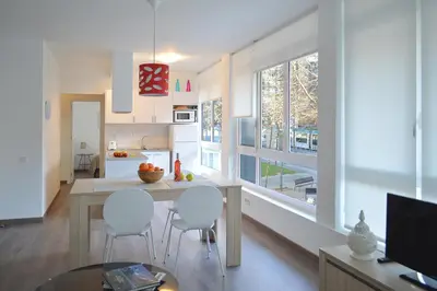 a kitchen with white walls and a table and chairs at CIUDADELA PARK 1 in Barcelona