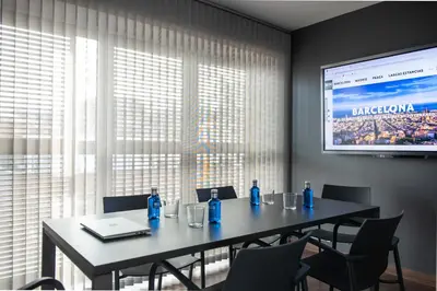 a conference room with a table and a projection screen at MH Apartments Urban in Barcelona