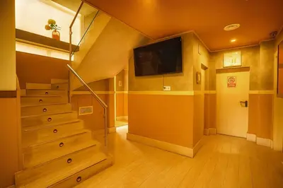 a living room with a staircase and a flat screen tv at Hotel Consentido in Granollers
