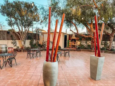 a group of poles in a courtyard with tables and chairs at Hotel Consentido in Granollers