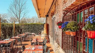 an outdoor patio with tables and chairs and flowers at Hotel Consentido in Granollers