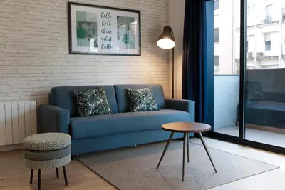 a living room with a blue couch and a table at MH Apartments Sant Pau in Barcelona