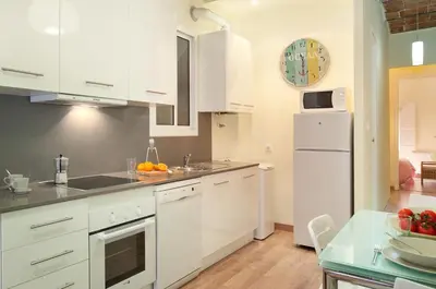 a kitchen with white cabinets and a white refrigerator at CON GRACIA in Barcelona