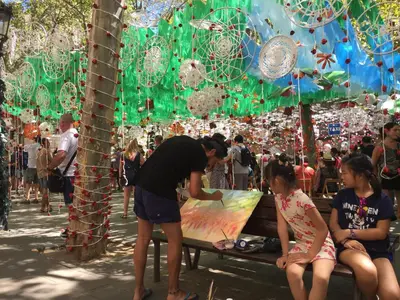 a man painting a canvas in a crowd of people at CON GRACIA in Barcelona