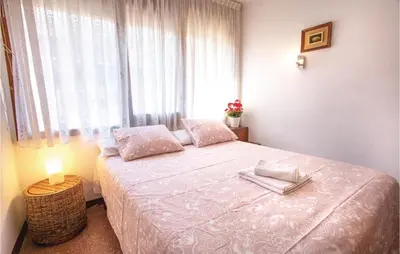 a bedroom with a large bed with a window at Stunning Apartment In Pineda De Mar in Pineda de Mar