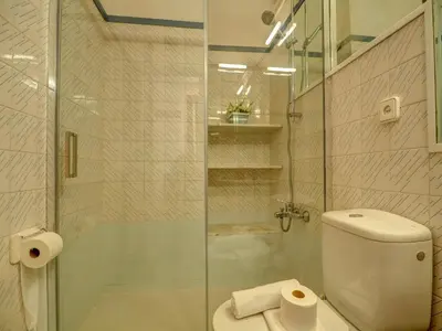 a bathroom with a toilet and a glass shower at Aquamarine Terrace Apartment by Hello Homes Sitges in Sitges