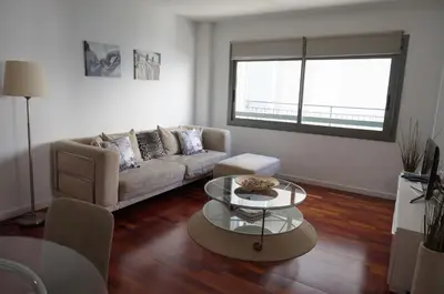 a living room with a couch and a table at Happy Holiday Beach Home in Sitges