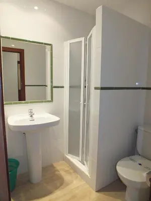a bathroom with a sink and a toilet and a mirror at Hotel Mitus in Canet de Mar