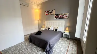 a bedroom with a bed and a balcony with a table at Des Artistes in Barcelona