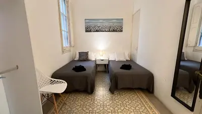 a bedroom with a bed and a lamp and a window at Des Artistes in Barcelona