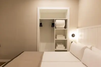 a bedroom with a white bed and a closet at Apartamentos Laforja in Barcelona