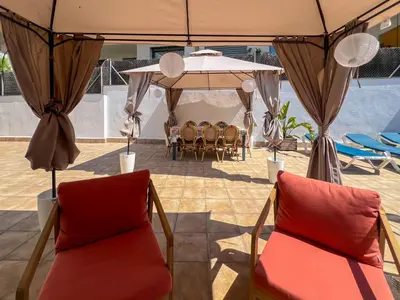 a group of chairs under a tent with a table at The Beach House Paradise by Hello Homes Sitges in Sitges