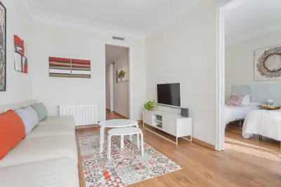 a white living room with a couch and a table at Art House Fira Apartments in Barcelona