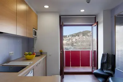 a kitchen with a door leading to a balcony at Abarco Apartments in Santa Coloma
