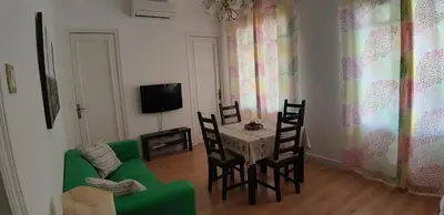 a living room with a green couch and a table and chairs at Piso Zona Plaza España, junto a Montjuic, in Barcelona