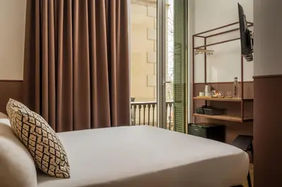 a hotel room with a bed and a window at BYPILLOW Ramblas in Barcelona