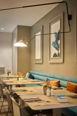 a restaurant with tables and chairs and a large window at Catalonia Gran Via BCN in Barcelona