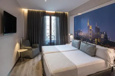 a hotel room with a bed and a view of a city at Catalonia Gran Via BCN in Barcelona