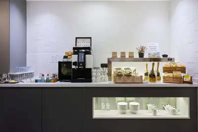 a coffee shop with a counter with cups on it at Catalonia Gran Via BCN in Barcelona