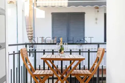 a wooden table and two chairs on a balcony at Sitges CENTRAL - En el corazón de Sitges in Sitges