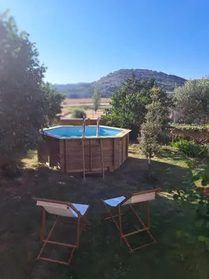 a swimming pool with two chairs and a table at Cal Puó Turismo Rural in Collsuspina