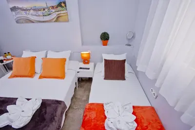 two beds in a small room with orange pillows at Barcelona City Seven Hostal in Barcelona