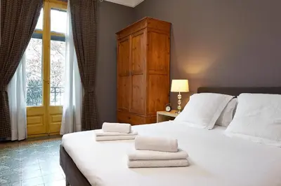 a bedroom with a large white bed with towels on it at Fewdays Barcelona Apartments in Barcelona