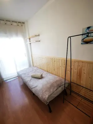 a bedroom with a white bed with a wooden door at Elsi's place in Premiá de Mar
